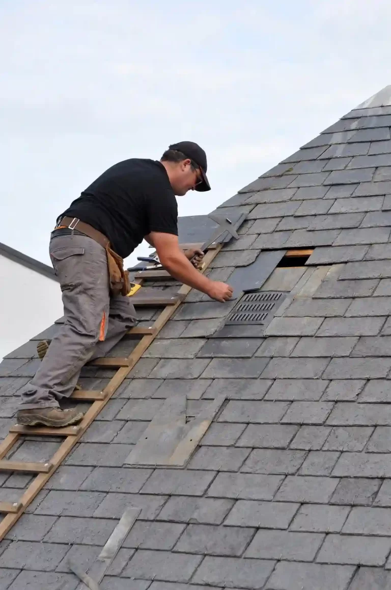 Un artisan couvreur répare un toit gâté
