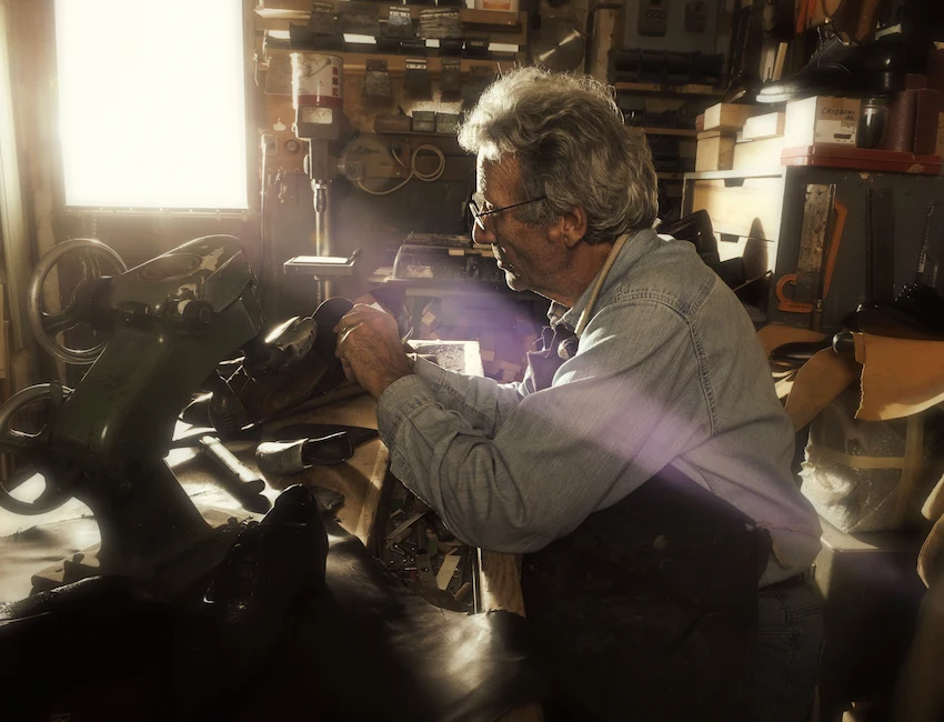 Un artisan cordonnier répare une chaussure